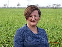 Katharina Moreau, Ergotherapeutin, lächelnd vor einem Feld
