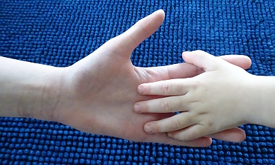 Eine Kinderhand liegt in einer Erwachsenenhand