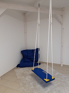 Therapieschaukel mit blauem Sitz im hellen Raum